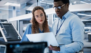 Two employees looking down at tablet reviewing data